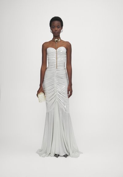 Strapless weißes Kleid, hergestellt aus glänzendem Stoff, mit Raffung, einem zentralen goldenen Ketten-Detail und einer figurbetonten Silhouette mit einem ausgestellten Saum.
