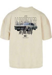 Beige bomulls t-skjorte med trykt grafikk av en klassisk bil, med fet tekst "M. Gonzales" og "In tha Hood" i kontrastfarger.