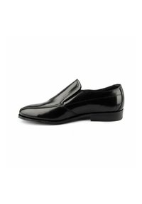 Zapato negro de piel sin cordones con punta afilada, superficie lisa y detalles de costura sutiles. Tacón de goma bajo para mayor estabilidad.