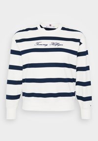Hvit hettegenser med marineblå horisontale striper, rund hals, og brodert "Tommy Hilfiger"-logo på brystet. Ribbestrikkede mansjetter og nederkant.
