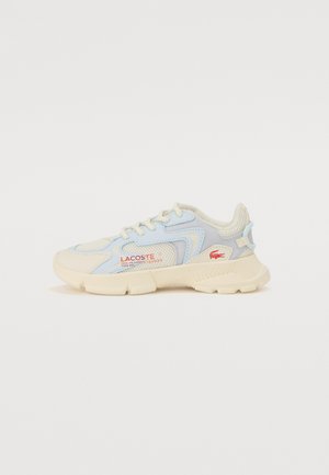Sneaker Lacoste in azzurro chiaro e beige cremoso, con materiali in mesh e sintetici, suola testurizzata e scritte rosse sul lato.