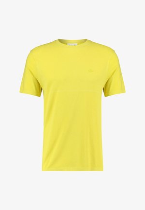 T-shirt jaune à manches courtes en tissu respirant, avec un col rond et un logo discret sur le côté gauche de la poitrine.