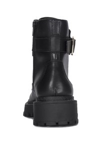 Stivaletto in pelle nera con tacco alto, dotato di zip laterale e un accento in metallo con fibbia, superficie texturizzata e suola robusta.