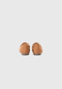 Tan suede loafers with a low profile and rounded backs. Features subtle stitching details along the sides and a smooth brown outsole.