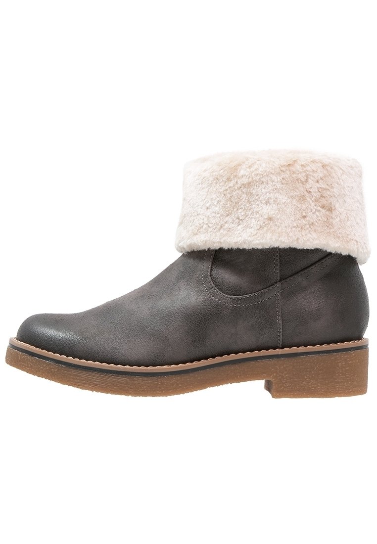 Bottine en cuir gris avec un revers en fausse fourrure blanche, bout arrondi, semelle épaisse marron et couture le long des côtés.