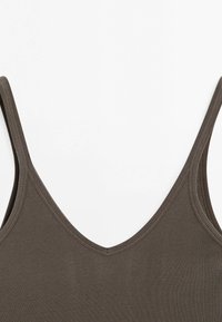 Bruine geribbelde tanktop met een diepe V-hals en dunne banden. De stof is rekbaar en heeft een textuur uitstraling.