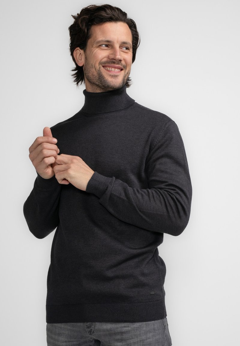 Ciemnoszary sweter z golfem wykonany z teksturowanej tkaniny, z prążkowanymi mankietami i dołem, z małą metką z logo blisko dolnej krawędzi.