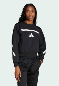 Black sweatshirt with white horizontal stripe and logo, featuring ribbed neckline and cuffs, paired with black joggers, smooth fabric texture.