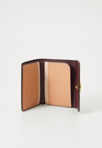 Portefeuille compact avec un extérieur bordeaux, texture en cuir lisse et intérieur beige. Comprend plusieurs emplacements pour cartes et une fermeture à pression.