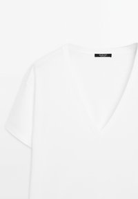 Witte V-hals T-shirt met korte mouwen, gemaakt van zachte stof. Voorzien van een label met "Massimo Dutti" op de halslijn. Eenvoudig, klassiek ontwerp.