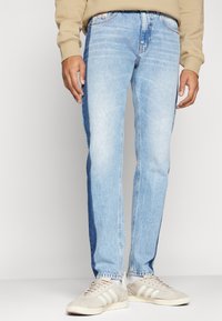 Ljusblå denimjeans med rak passform, med urtvättade områden, en klassisk femficksdesign och kontrasterande sidopaneler.