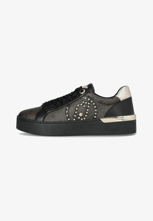 Sneaker nera con tomaia texturizzata, dotata di dettagli in oro e argento, borchie decorative e una suola nera spessa. Branding sul lato.