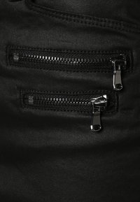 Shorts in denim neri con due tasche con zip, ciascuna con rifiniture in tessuto nero e accessori in argento lucido. Tessuto liscio senza motivi visibili.