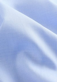Helles blaues Gewebe mit einer feinen, strukturierten Webart. Die Oberfläche wirkt glatt und weist ein dezentes Rippmuster auf.