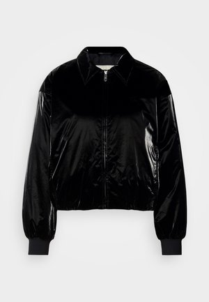 Black velvet bomber jacket with a collar, front zipper, ribbed cuffs, and hem. Glossy texture with a relaxed fit and drop shoulders.