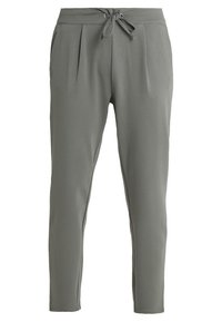 Lichtgrijze taperende broek met een tailleband met trekkoord, plooidetails aan de voorkant en zachte, rekbare stof. Glad oppervlak door het hele kledingstuk.