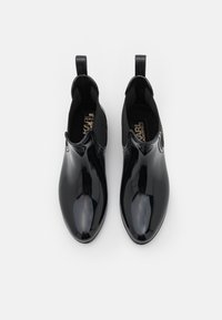 Botas de tobillo negras pulidas con una superficie lisa y reflectante, paneles laterales elásticos y tiradores para ponérselas fácilmente. Plantilla de textil.