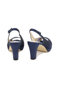 Sandali con tacco color blu navy, in tessuto strutturato, con apertura sul retro, design perforato e tacco curvo. Chiusura con fibbia sulla cinghia della caviglia.