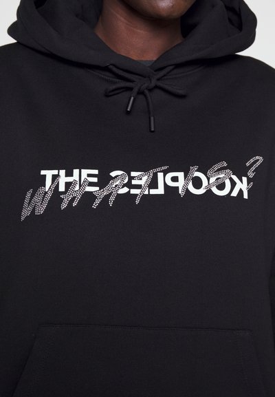 Black hoodie with a front pocket and drawstring hood. Features white text "THE KOOLPEST?" embellished with rhinestones in a distressed style.