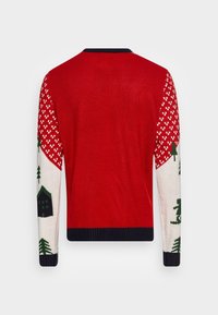 Czerwony sweter o teksturowanym wykończeniu, z białym i zielonym wzorem przedstawiającym drzewa i dom na rękawach i ramionach.