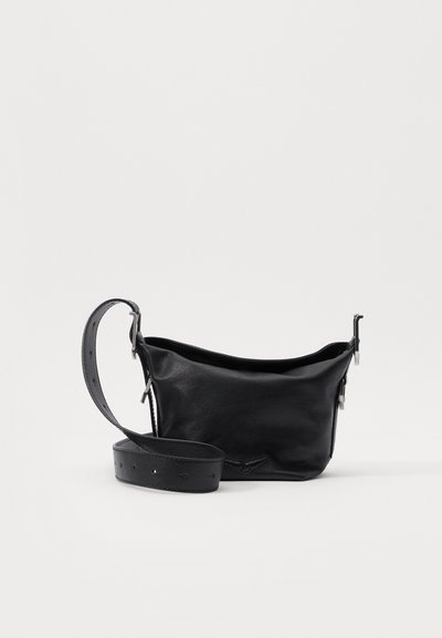 Petit sac en cuir noir avec une forme courbée et une bandoulière réglable. Présente des détails en métal argenté et une finition lisse et texturée.