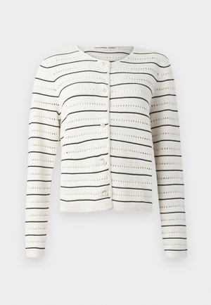 Witte cardigan met zwarte horizontale strepen en een opengewerkt patroon. Kenmerkt zich door een ronde halslijn en parelachtige knopen aan de voorkant.