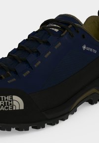 Μπλε και μαύρο πεζοπορικό παπούτσι The North Face Gore-Tex με μαύρα κορδόνια και ανθεκτική σόλα, από την μπροστινή πλευρά.