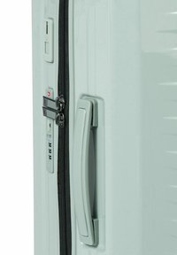 Valigia rigida di colore grigio chiaro con zip nera. Presenta una maniglia laterale e un lucchetto a combinazione con tre quadranti. Design testurizzato per una presa sicura.