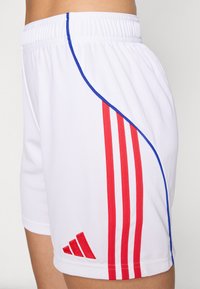 Hvite treningsshorts med røde striper og blå piping. Stoffet virker glatt, med en brodert logo på venstre nedre side.