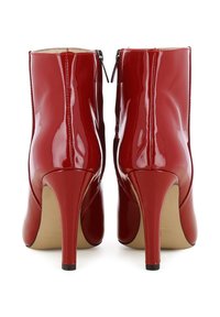 Rote Lacklederschuhe bis zum Knöchel mit spitzem Zehenbereich, schlanken Stiletto-Absätzen und Reißverschlüssen hinten. Glatte, glänzende Oberfläche mit vertikalen Nähten.