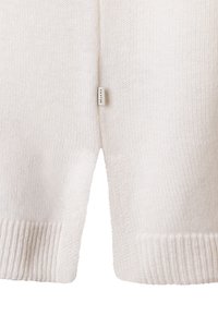 Maglione bianco lavorato a maglia con finitura strutturata, con polsini e orlo a coste. Un piccolo marchio è visibile vicino alla cucitura laterale.