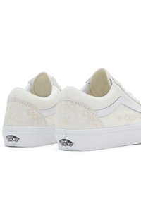 Białe płócienne sneakersy z zamszowymi akcentami, płaskimi sznurówkami i teksturowanym wzorem na pięcie. Posiadają białą gumową podeszwę oraz naszywkę z logo.