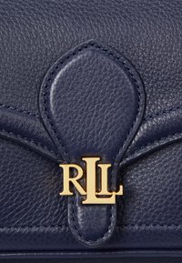Borsa a mano in pelle blu navy con finitura testurizzata, caratterizzata da hardware con logo in oro "RLL" e cuciture dettagliate sulla patta. Design compatto con forma curva.
