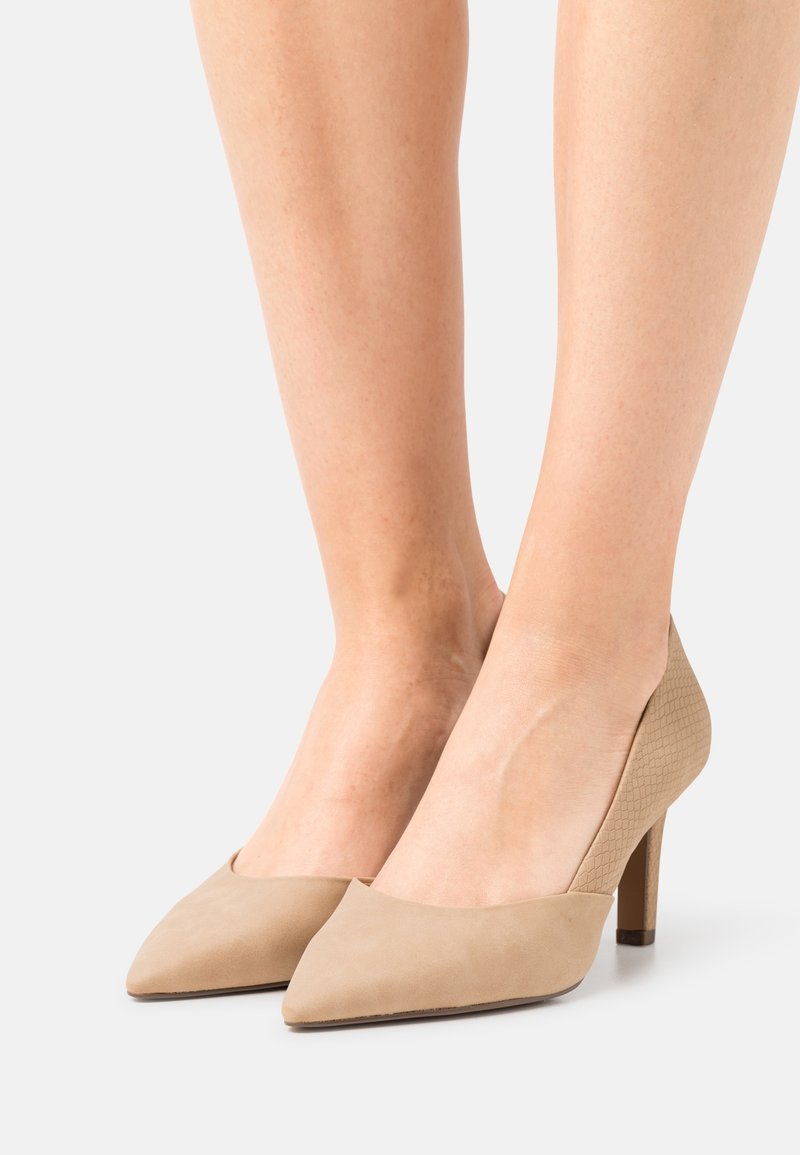 Escarpins beiges à talons hauts avec un design à bout pointu. Fabriqués en daim texturé, avec une section avant lisse et un talon texturé.