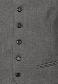 Cinq boutons noirs attachés sur une veste de costume grise avec une poche horizontale étroite du côté droit.
