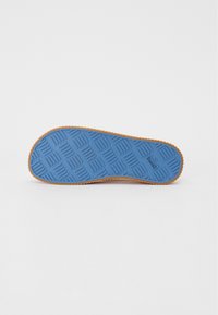 Sole of a shoe featuring a blue rubber base with a textured grid pattern and an orange border, designed for grip and durability.