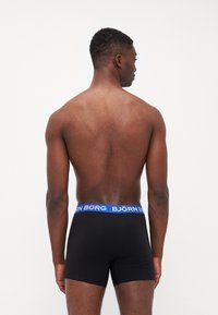 Boxeri negri dintr-un material moale, cu un brâu elastic albastru pe care este inscripționat textul "BJÖRN BORG". Textură netedă, design ajustat.