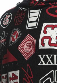 Felpa nera con stampe grafiche rosse e bianche, tra cui loghi, numeri e forme. Il materiale appare morbido con una texture liscia.
