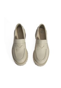 Beige leren instappers met een ronde neus en een gestikt ontwerp. Dikke rubberen zool met een gestructureerd tractionpatroon en een geperst logo aan de binnenkant.