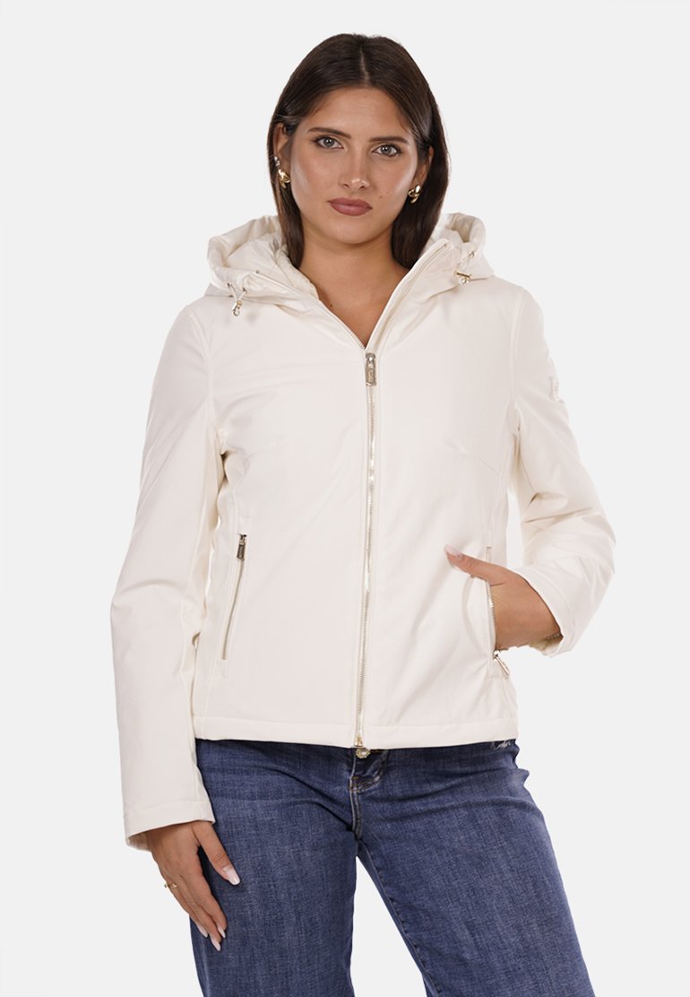Giacca bianca con zip e cappuccio, dotata di tasche laterali, texture morbida e dettagli in metallo sulla zip, indossata sopra jeans blu.