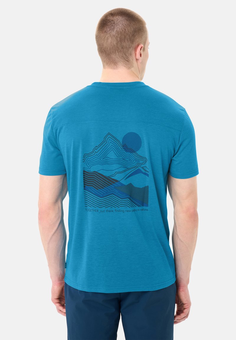 Homme portant un T-shirt bleu avec un graphique de montagne et de soleil ainsi que le texte « TOGETHER_out there, finding new paths in nature » au dos.