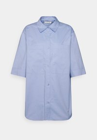 Camisa de manga curta azul clara feita de algodão, com fecho à frente por botões e dois bolsos no peito, apresentando um colarinho clássico e bainha reta.