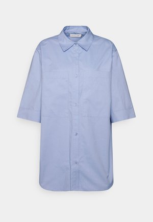 Camisa de manga curta azul clara feita de algodão, com fecho à frente por botões e dois bolsos no peito, apresentando um colarinho clássico e bainha reta.
