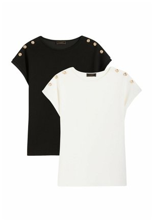 Zwart-witte topjes met korte mouwen en ronde hals, versierd met gouden knopen op de schoudernaden, plat gelegd op een witte achtergrond.