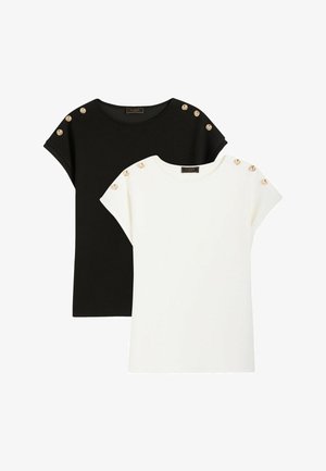 Hauts à manches courtes noirs et blancs avec col rond, décorés de boutons dorés sur les coutures des épaules, posés à plat sur un fond blanc.