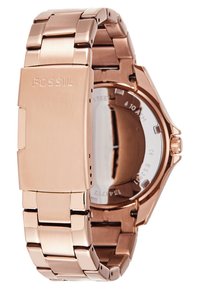 Reloj de acero inoxidable color rosa dorado con pulsera de eslabones metálicos y una caja redonda. Cuenta con una esfera de cristal transparente y el logo de la marca grabado en el cierre.