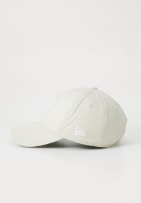 Hellgraue Kappe aus Stoff mit einem gebogenen Schirm. Verziert mit einem weißen gestickten Logo und Nähdetails, ausgestattet mit sechs Belüftungslöchern.