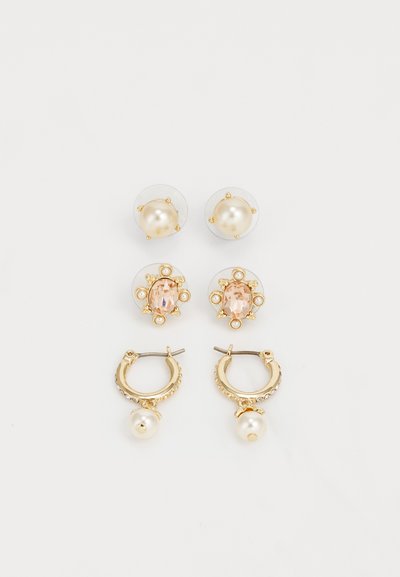 Guldsmykker sæt: to par perleøreringe, et med klar baggrund, og et par guld creoler med en perledrop og rhinestone accenter.