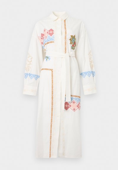 Λευκό φόρεμα με μακριά μανίκια, κουμπιά μπροστά, ζώνη στη μέση και πολύχρωμη γεωμετρική και ανθική κεντητική στο στήθος, τα μανίκια και το τελείωμα.