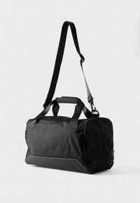 Borsa da viaggio nera in tessuto resistente, dotata di due manici superiori, tracolla staccabile e chiusura con zip. Arricchita da un lato con una finitura testurizzata.